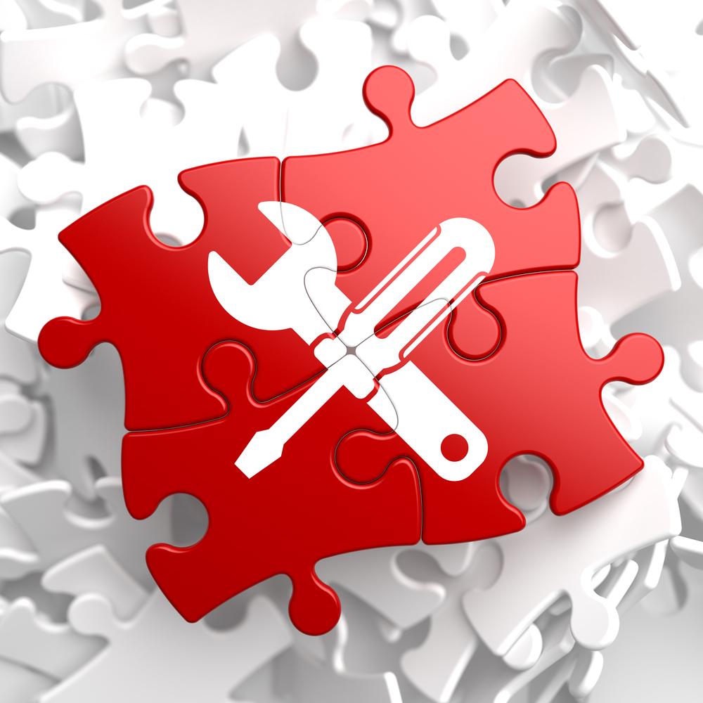 Red puzzle pieces with a wrench and screwdriver fit together